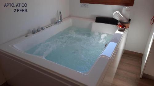 eine Whirlpool-Badewanne mit blauem Wasser im Badezimmer in der Unterkunft El Tranco Apartamentos in Villel