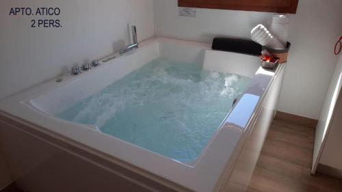 a jacuzzi tub with blue water in a bathroom at El Tranco Apartamentos in Villel