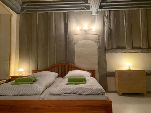 a bedroom with a bed with two green pillows on it at Historische Renaissance-Stube Kahla in Kahla