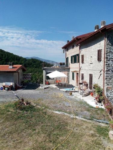 un edificio con patio e ombrellone bianco di Al Mostarolo a Berceto