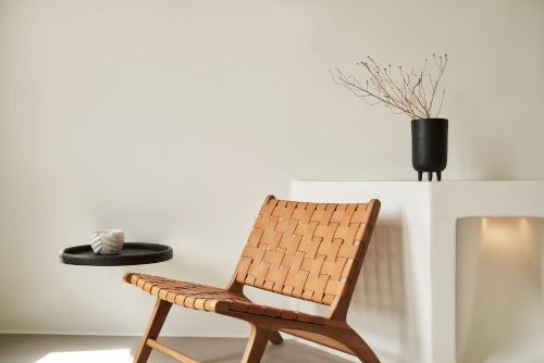 a rattan chair with a hat on a table at Orama Hotel & Spa in Fira