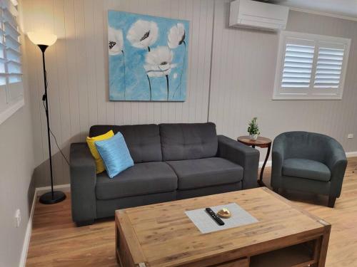 a living room with a couch and a coffee table at Cute City Cottage - 2 Bedroom - The Strand in Townsville