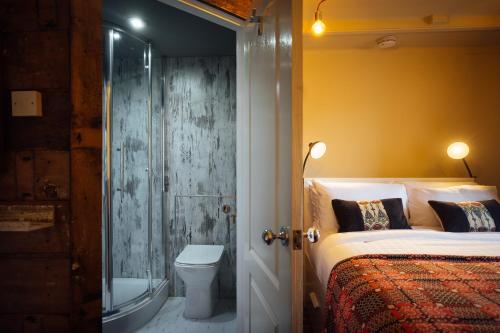 een slaapkamer met een douche, een bed en een toilet bij Penrhiw Farm B & B in Goodwick