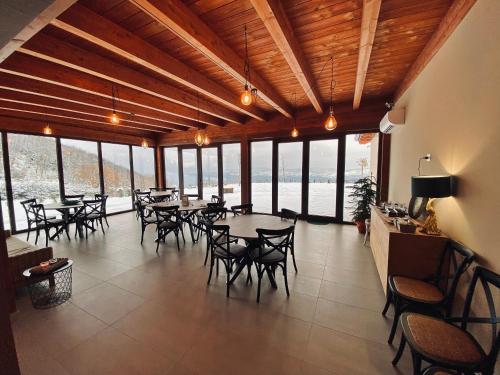 a dining room with tables and chairs and windows at Baita Pavò in Trivento