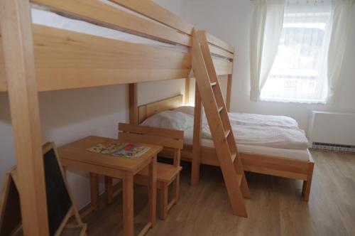 a bedroom with two bunk beds and a table at Apartmá 11 Deštné v Orlických horách in Deštné v Orlických horách