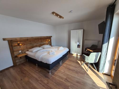 a bedroom with a large bed with a wooden headboard at Hotel Pension Annerlhof in Maria Alm am Steinernen Meer