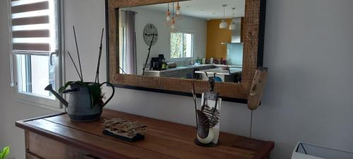- un miroir au-dessus d'une table en bois dans l'établissement La bellevue, à Montcléra
