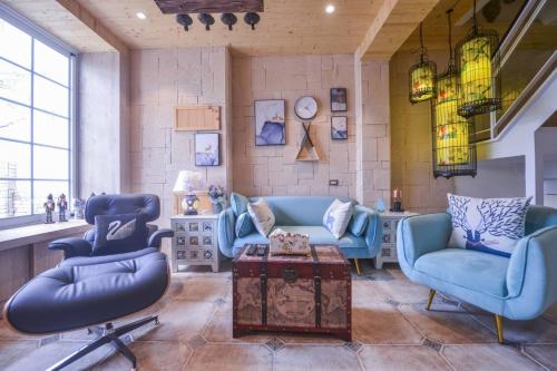 a living room with blue chairs and a table at 白鹿詩行旅 in Tainan