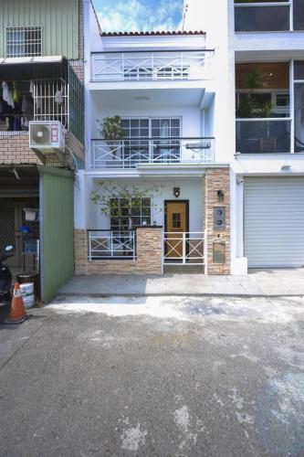 a white building with a gate and a garage at 白鹿詩行旅 in Tainan
