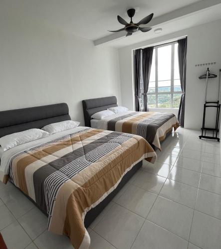 a bedroom with two beds and a ceiling fan at Cameron 1Room Apartment @ Emerald Avenue Brinchang in Brinchang