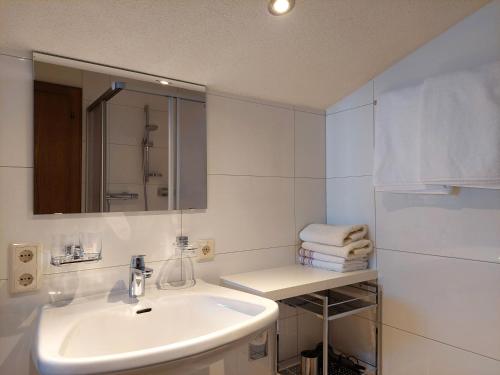 ein weißes Badezimmer mit Waschbecken und Spiegel in der Unterkunft Haus Moritz in Nauders
