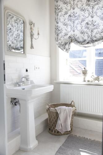 a white bathroom with a sink and a window at SCHLEI LIEBE in Arnis