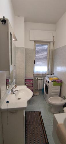 un bagno con lavandino e lavatrice di Sweet home in Ostia a Lido di Ostia
