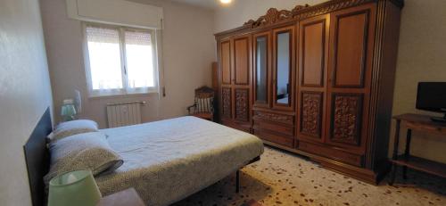 una camera da letto con un letto e un grande armadio in legno di Sweet home in Ostia a Lido di Ostia