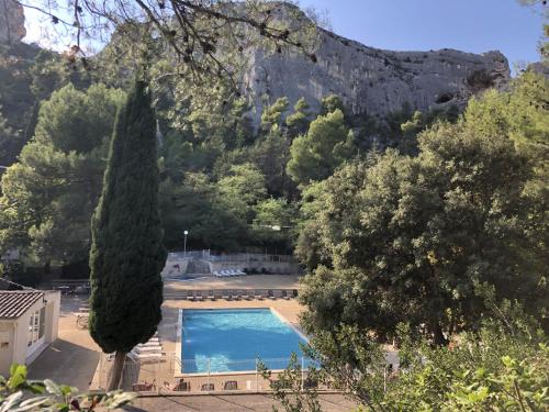 una piscina con una montaña en el fondo en Camping de la Vallée Heureuse en Orgon