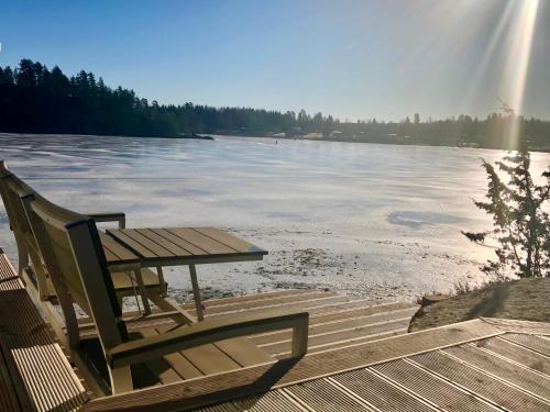 a table and chair sitting on a dock next to the water at Lyseren waterfront cabin in Omberg