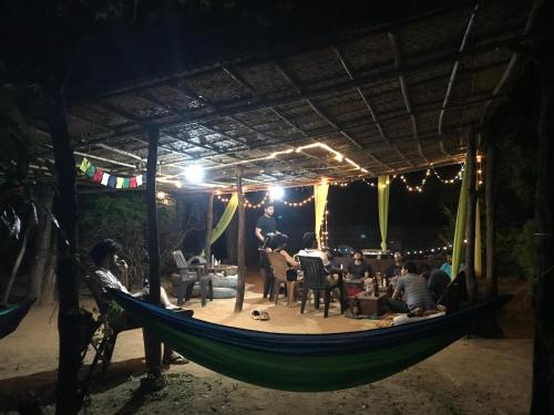um grupo de pessoas sentadas numa rede à noite em Tusker Tribe Hostel em Gokarna
