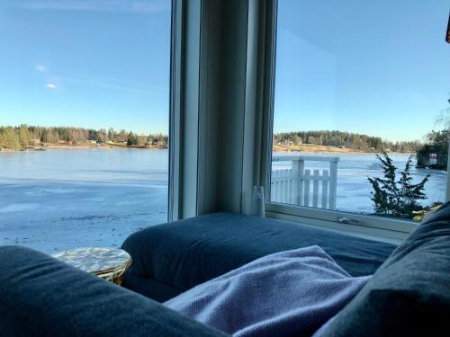a room with a large window with a view of the water at Lyseren waterfront cabin in Omberg