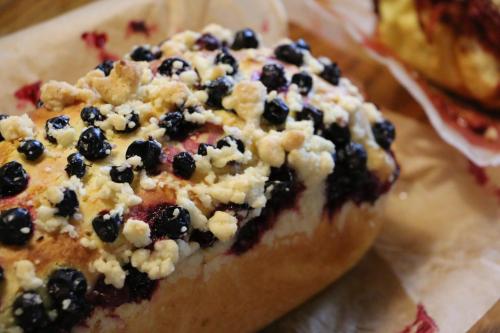 a piece of pizza with blueberries on top of it at Pszczelarnia Dom Pracy Twórczej in Wilkanów