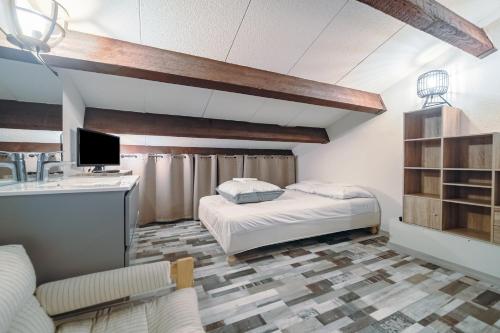 une chambre avec un lit, un bureau et une télévision dans l'établissement Le Tetrao, aux Angles