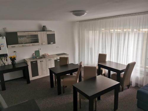 a living room with two tables and a kitchen at CASA SONIA in Târgu Jiu