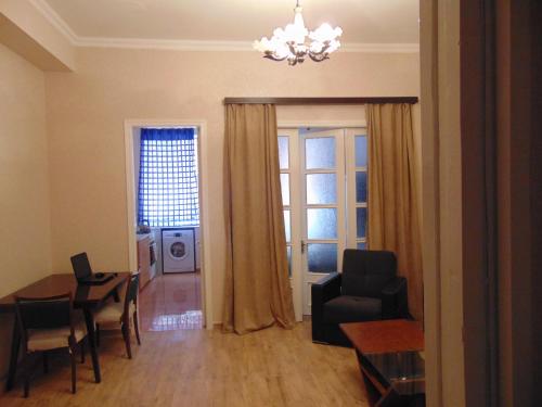 a living room with a table and a chair at Apartment in the center of the city - Vera in Tbilisi City