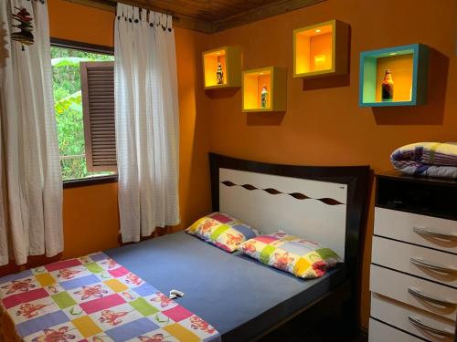 een slaapkamer met een bed en een raam bij Casa em Lumiar - Barulhinho do Rio in Lumiar