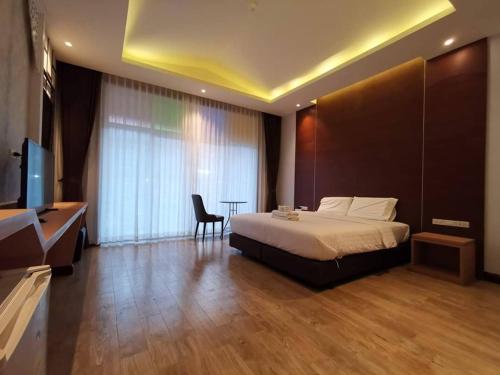 a bedroom with a bed and a desk and a television at Southern Airport Hotel Hatyai in Hat Yai