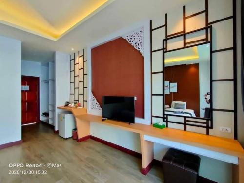 a living room with a desk and a large mirror at Southern Airport Hotel Hatyai in Hat Yai