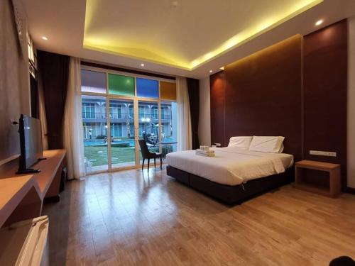 a bedroom with a bed and a tv and a window at Southern Airport Hotel Hatyai in Hat Yai