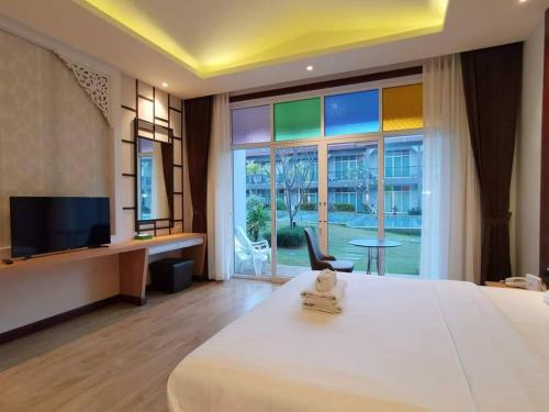 a room with a bed and a tv and a window at Southern Airport Hotel Hatyai in Hat Yai