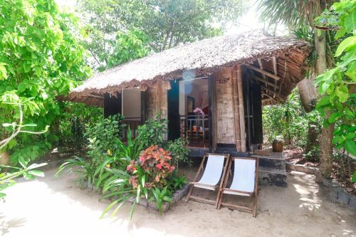 a small hut with two chairs in front of it at Whale Island Resort in Dam Mon