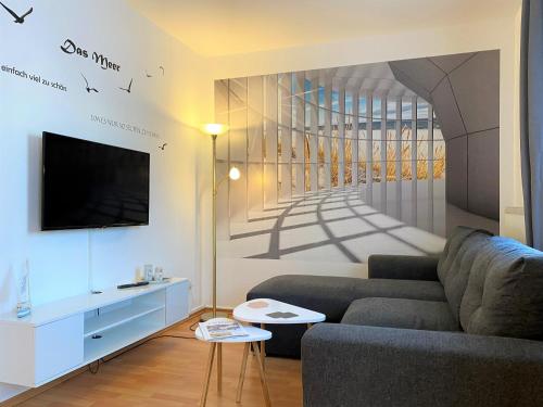 ein Wohnzimmer mit einem Sofa und einem Gemälde einer Treppe in der Unterkunft Appartementhaus Sonnenschein in Binz