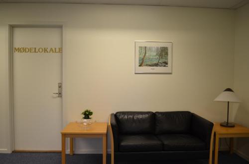 a black leather couch in a room with a door at BB-Hotel Rønne Bornholm in Rønne