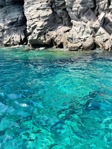 a large body of blue water next to a rocky cliff at Chiusa Di Carlo Agriturismo in Avola