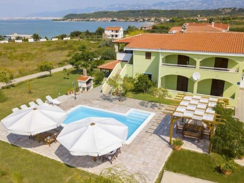 an aerial view of a house with a pool and umbrellas at Lovely apartment with swimming pool in Ljubač