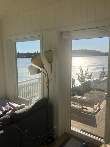 a living room with a window with a view of the ocean at Lyseren waterfront cabin in Omberg