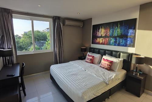 a bedroom with a bed and a large window at Villa Versace Residence in Patong Beach