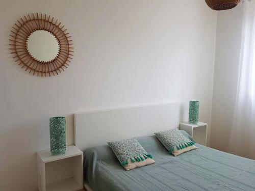 une chambre avec un lit avec un miroir au mur dans l'établissement Maison charmante à Sainte-Marie avec grand jardin, à Sainte-Marie-la-Mer