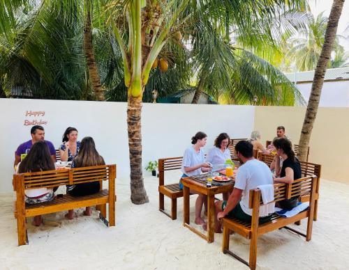 un gruppo di persone seduti ai tavoli in un ristorante di Vacanza Mathiveri a Mathiveri