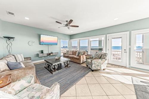 a living room with a couch and chairs and a tv at Grotto on the Gulf in Fort Morgan