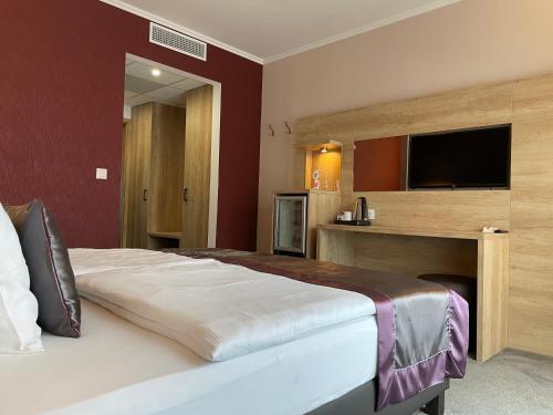 a bedroom with a large bed with a flat screen tv at Villa Aruba & Private SPA Suites in Keszthely