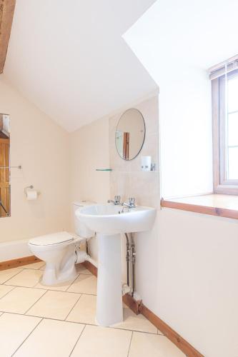 a white bathroom with a sink and a toilet at Yr Wyddfa Cottage Anglesey in Llanfairpwllgwyngyll