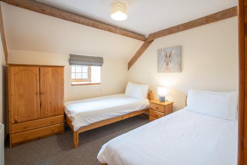 1 dormitorio con 2 camas y ventana en Yr Wyddfa Cottage Anglesey, en Llanfairpwllgwyngyll