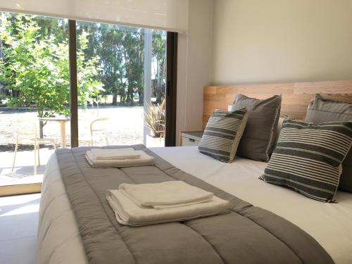a large bed with two folded towels on it at Portal del Callvú in Azul