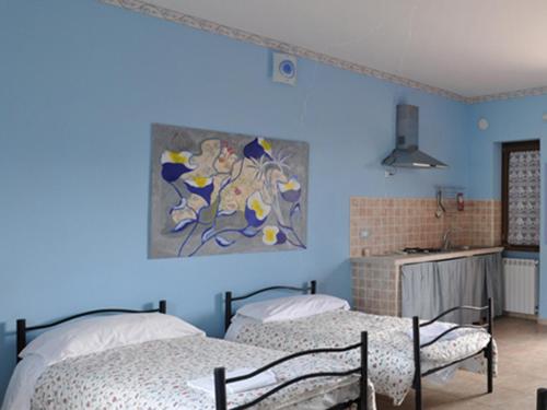 2 camas en una habitación con paredes azules en Country House Al Faraone, en Poggio Picenze