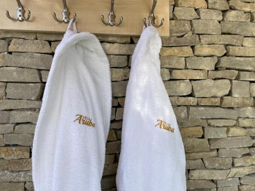 two white towels are hanging on a wall at Villa Aruba & Private SPA Suites in Keszthely