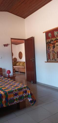 a bedroom with a bed and a door with a mirror at L'elephant blanc in Grand-Bassam