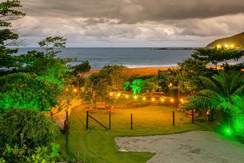 a view of a park with the ocean at night at Penareia Floripa Beach Hotel in Florianópolis