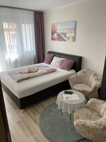 - une chambre avec un lit, une chaise et une table dans l'établissement Classic City Apartman, à Szeged